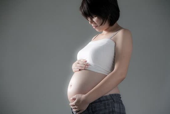 Pregnancy Cramps Photo of woman holding her abdomen with the text: 'Managing Pregnancy Cramps'