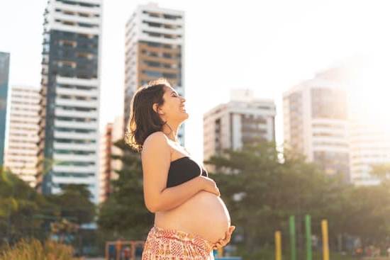 Image of a happy pregnant woman with a hand on her heart, possible sign of heartburn in pregnancy