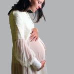 woman embracing her belly with a smile