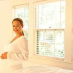 Woman holding her stomach, experiencing nausea pregnancy symptoms