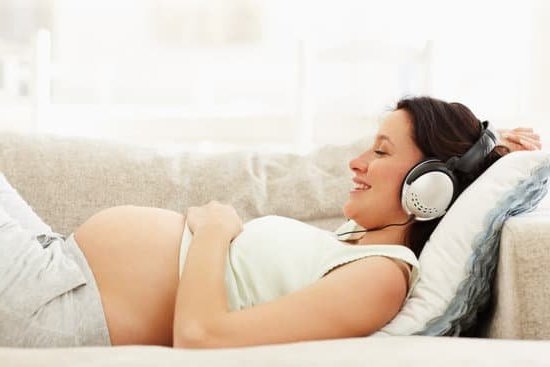 Image of a woman holding a pregnancy test with the text 'What are signs of pregnancy' below it